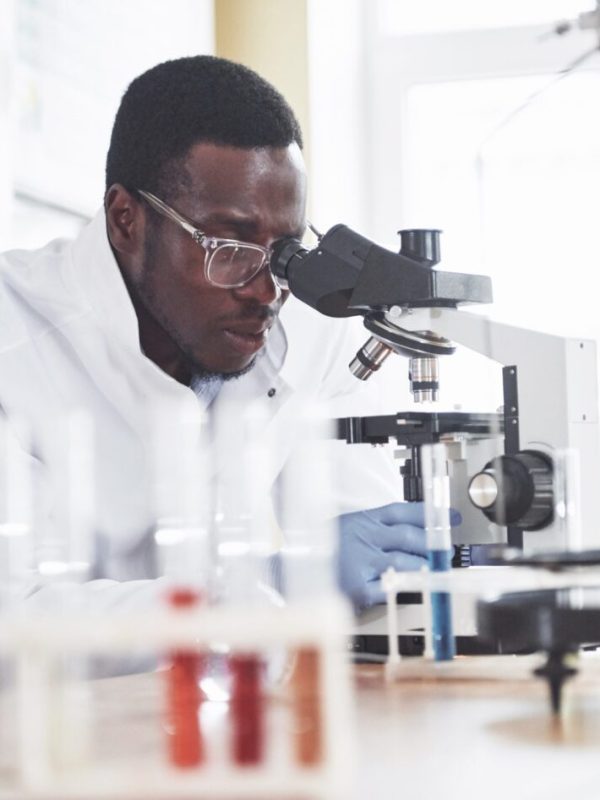 The scientist works with a microscope in a laboratory conducting experiments and formulas. The scientist works with a microscope in a laboratory conducting experiments and formulas